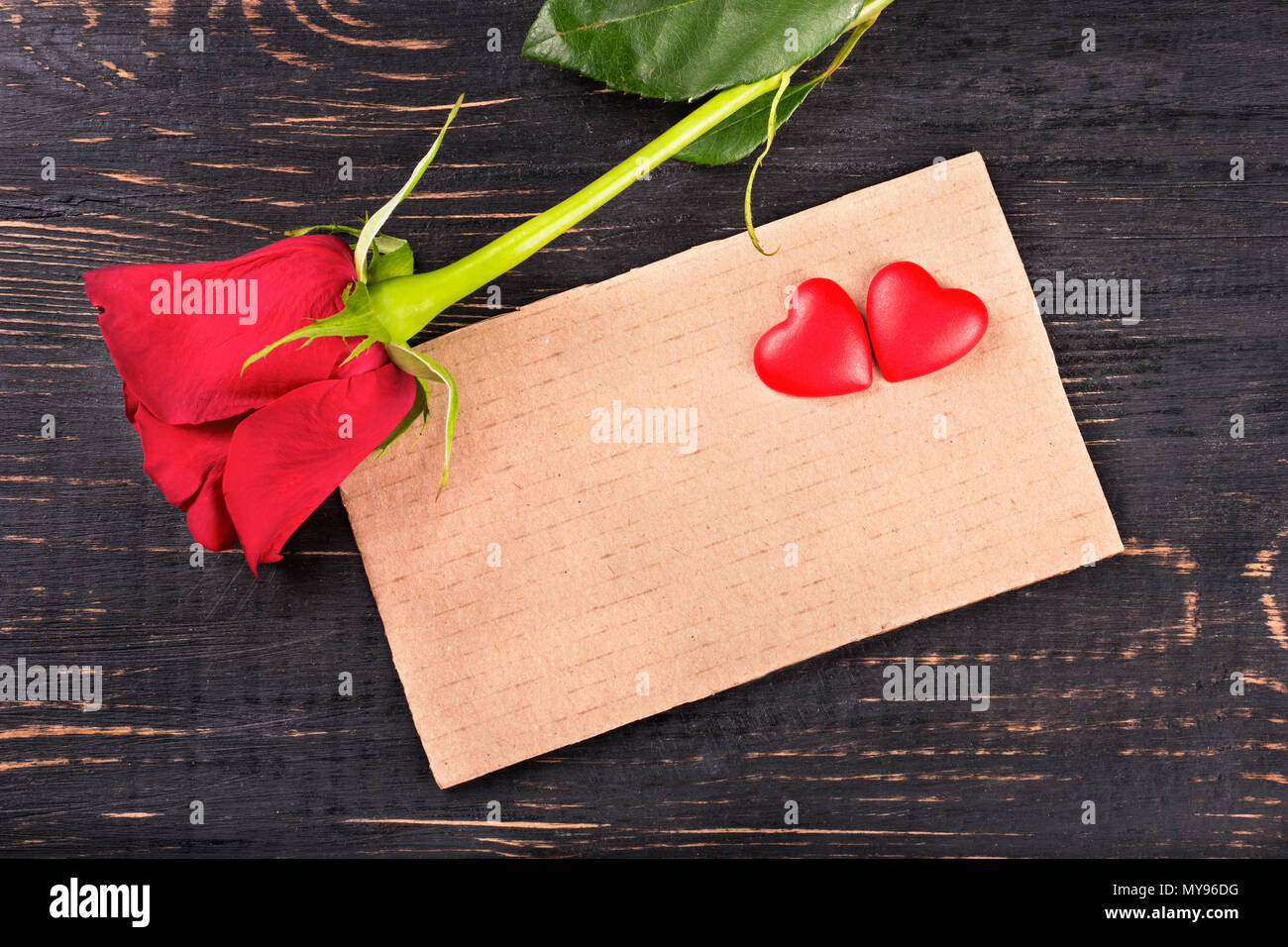 Blank valentine card with red rose and heart on a wooden background ...