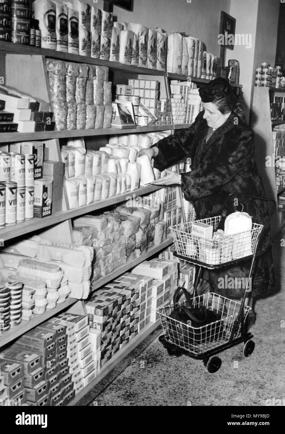 A customer takes the desired product off the shelf. The third self-service  store in western Germany opened in Frankfurt am Main in December 1949. The  shop was furnished by the company Meyer