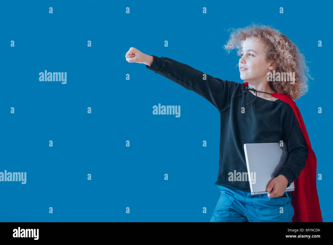 Boy dressed up as a superhero goes to robotic and programming classes, coding superhero concept Stock Photo