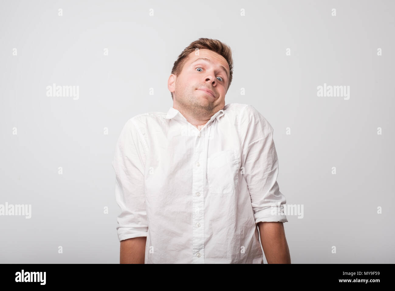 Portrait of handsome caucasian guy being surprised and clueless, being insecure and not sure about answer Stock Photo