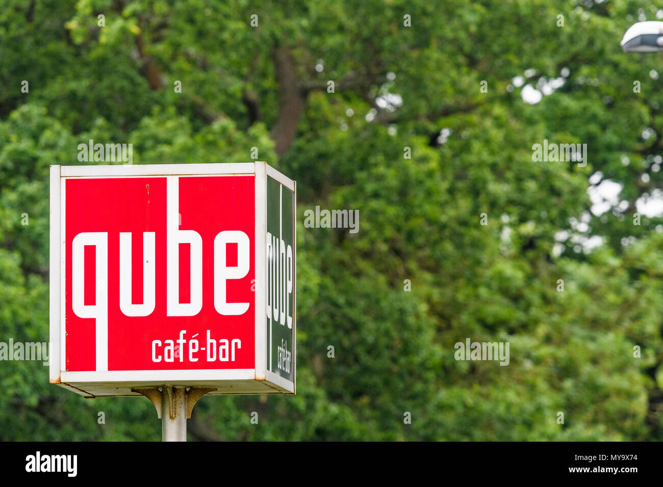 Red and white sign for the Qube cafe bar in the town center of Corby, Northamptonshire, England. Stock Photo