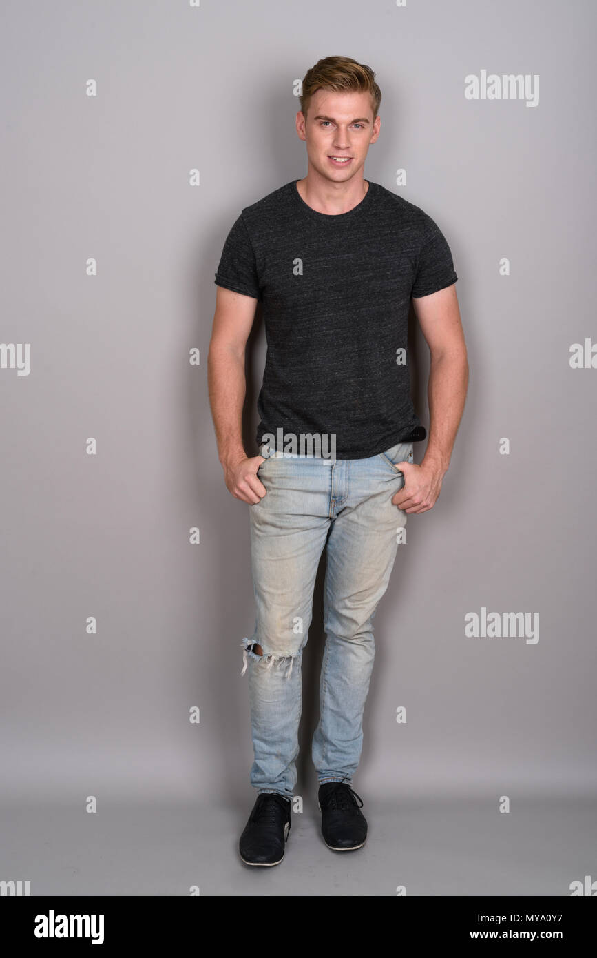 Young Handsome Man With Blond Hair Wearing Gray Shirt