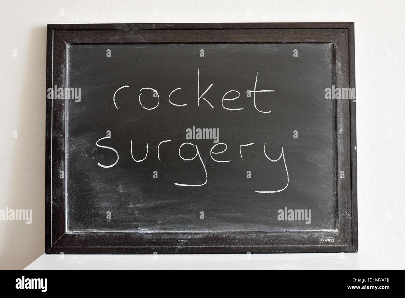 Rocket surgery written in white chalk on a blackboard Stock Photo