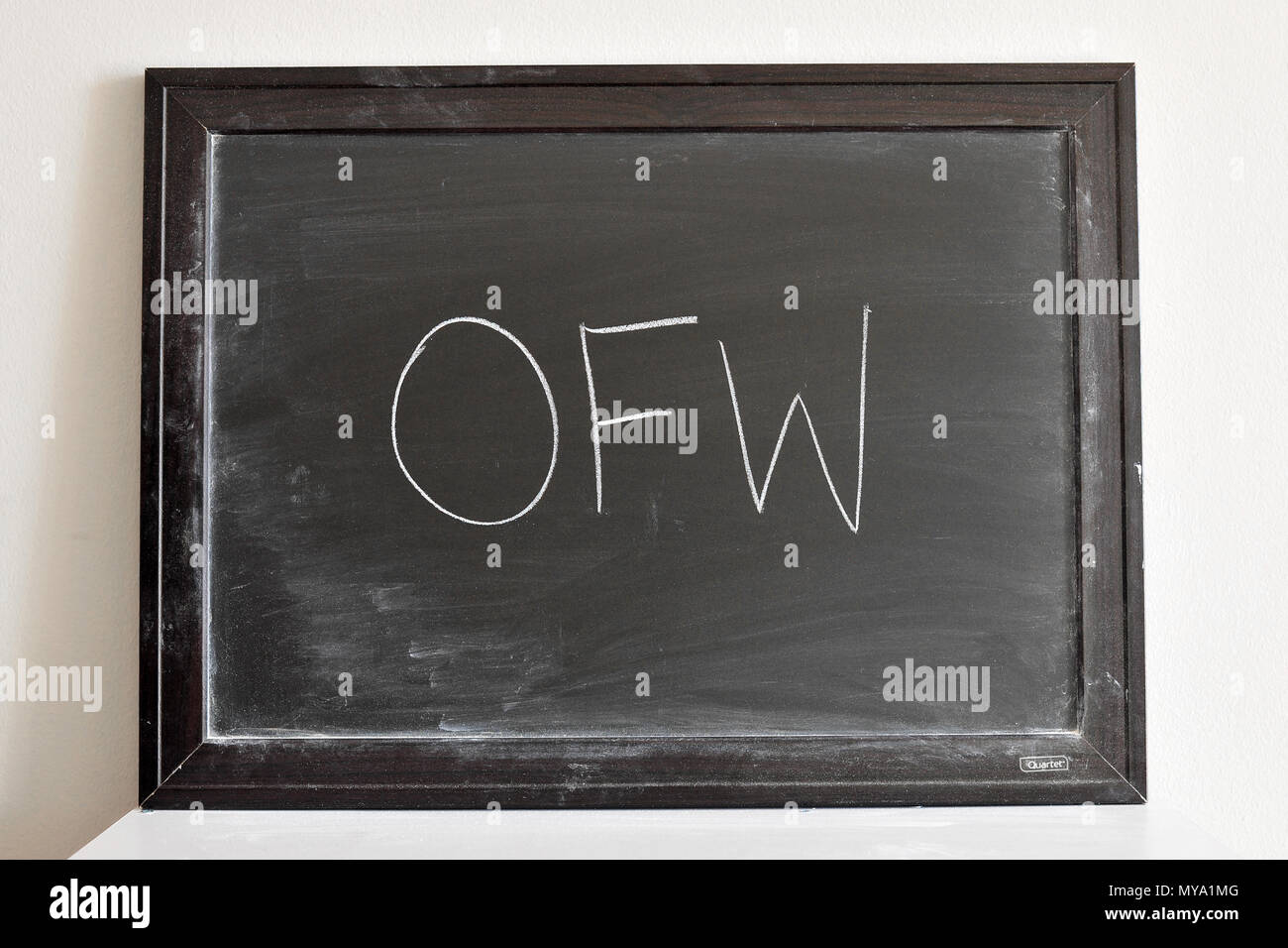 OFW written in white chalk on a blackboard Stock Photo
