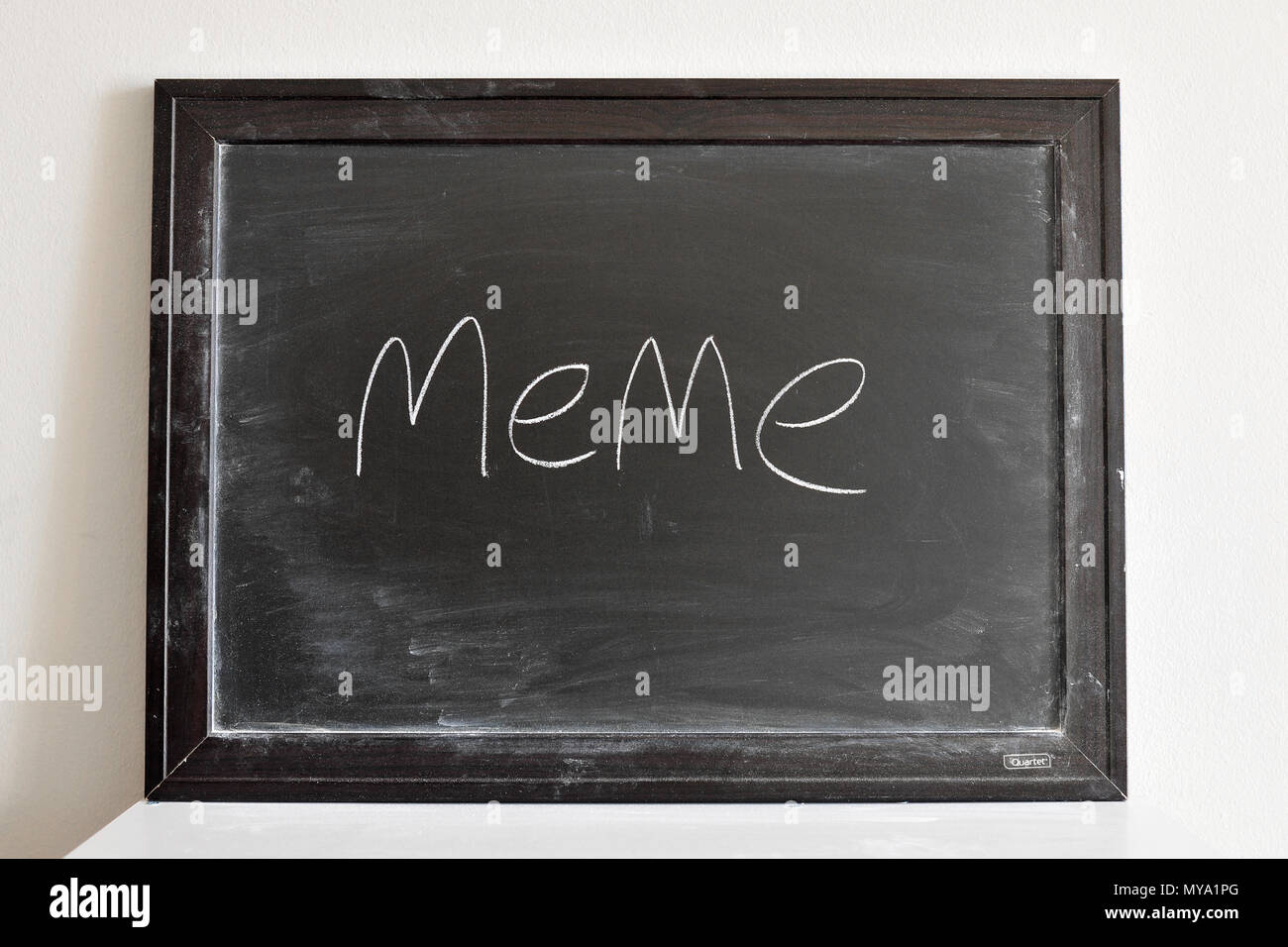 meme written in white chalk on a blackboard Stock Photo