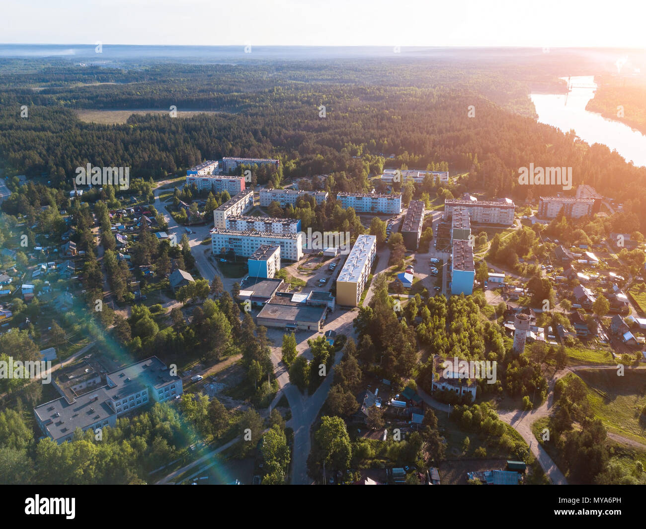 Flying over urban-type settlement Nikolskiy, Svir river and summer green forests of Leningrad region, Russia. Stock Photo
