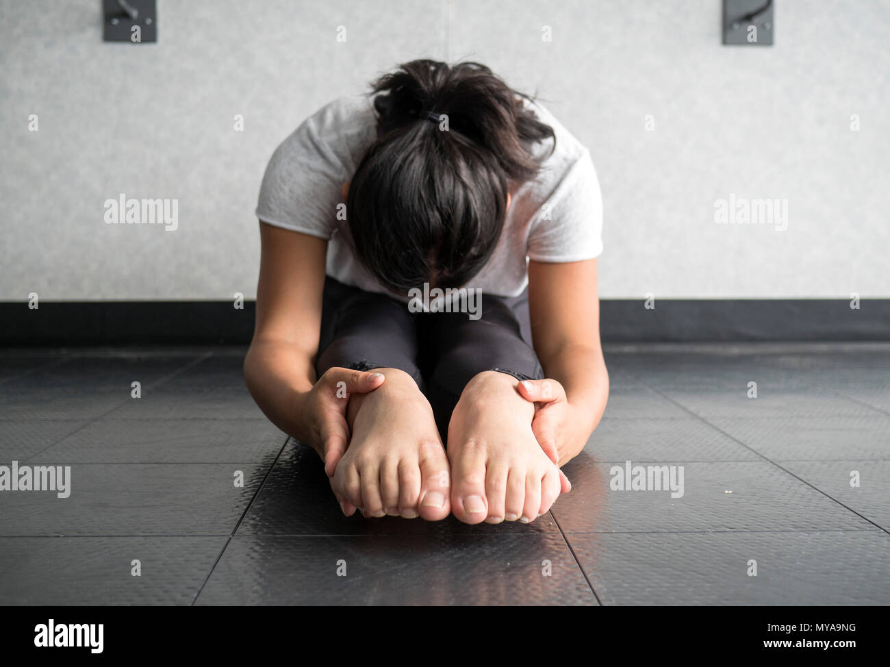 Young woman performing and sit and reach to stretch hamstrings and increase flexibility Stock Photo