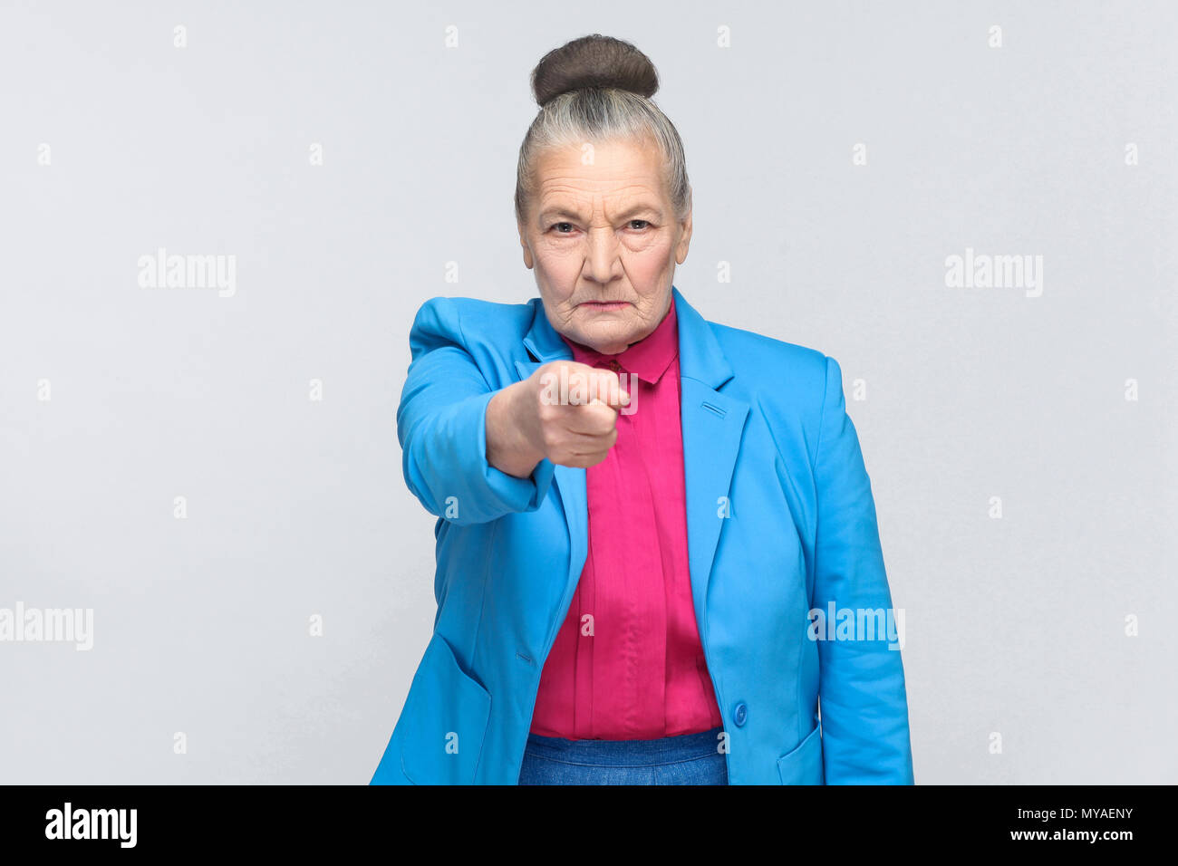 Hey you! Woman pointing at camera finger with serious face. Emotion and feelings concept. Portrait of expressive grandmother standing with collected g Stock Photo