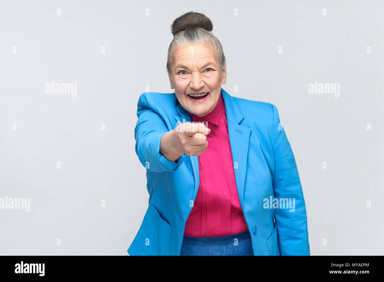 Beautiful woman pointing finger at camera, toothy smiling. Emotion and feelings Portrait of handsome expressive grandmother standing with collected gr Stock Photo