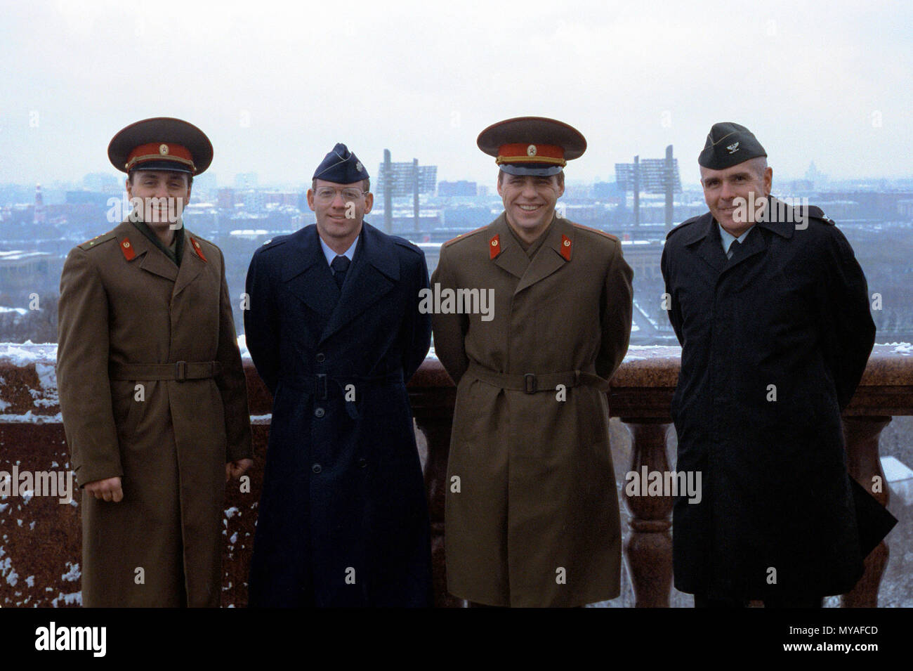 COL David Kiernan, right, chief of information, U.S. Army, and LTC Michael Perini, second from left, publisher of the U.S. Air Force magazine Airman, stand with their translators, CAPT Victor Bereznoy, left, and MAJ Ivan Skrylnik, on a bridge over the Moscow River.  The American officers are visiting the Soviet Union as part of a U.S./Soviet exchange program. Stock Photo