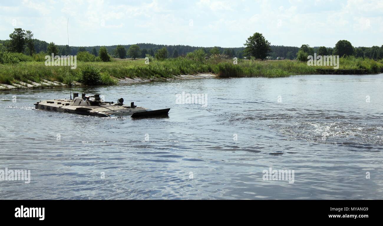 Troops in a Polish BWP-1 Amphibious Tracked Infantry Fighting Vehicle navigate a water obstacle during Saber Strike 18 in Wierzbiny, Poland, on June 04, 2018, June 4, 2018. Saber Strike 2018 is the eighth iteration of the longstanding U.S. Army Europe-led cooperative exercise designed to enhance interoperability among allies and regional partners. (Michigan Army National Guard photo by Capt. Tyler Piper/released). () Stock Photo