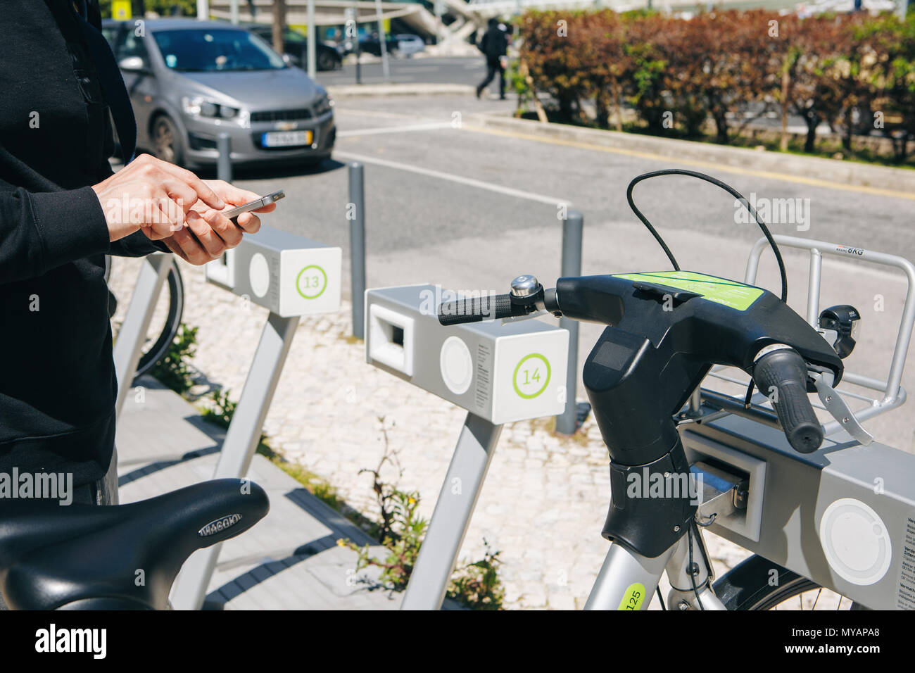 Portugal, Lisbon 29 april 2018: man or tourist rents bicycle or city alternative ecological transport using the mobile app on your phone Stock Photo