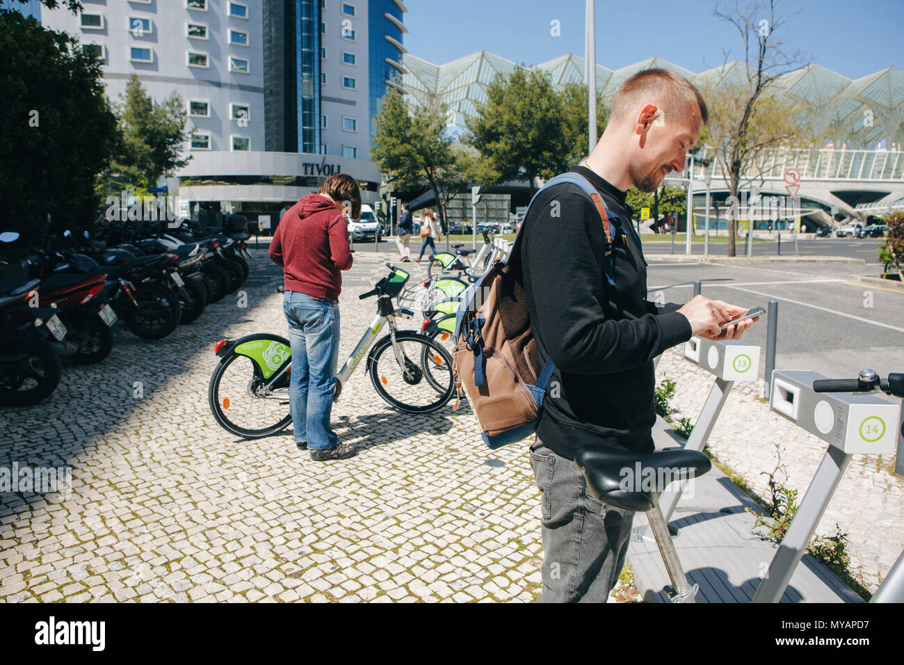 Portugal, Lisbon 29 april 2018: man or tourist rents bicycle or city alternative ecological transport using the mobile app on your phone Stock Photo