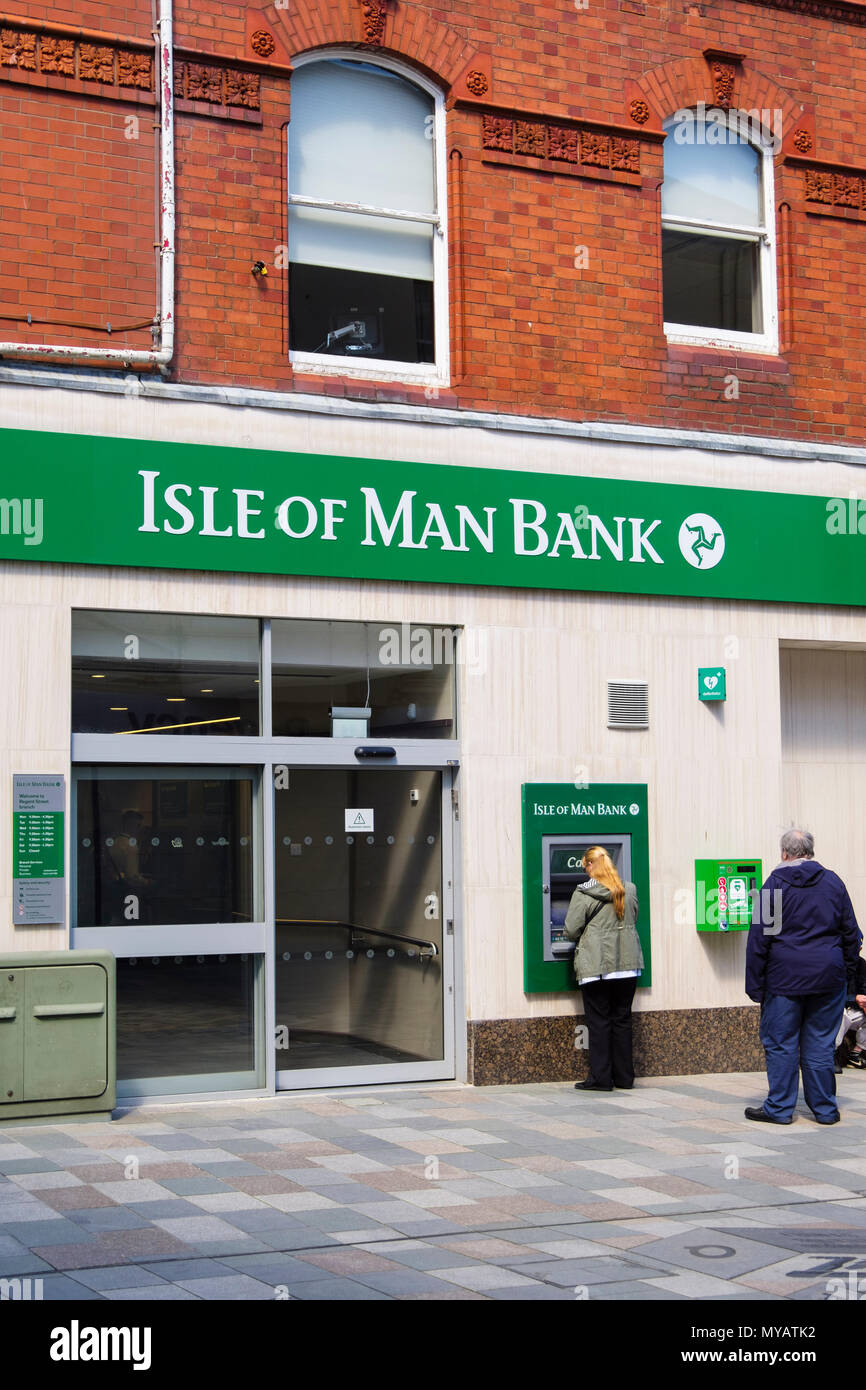 People using a cashpoint ATM outside Isle of Man Bank branch in Douglas, Isle of Man, British