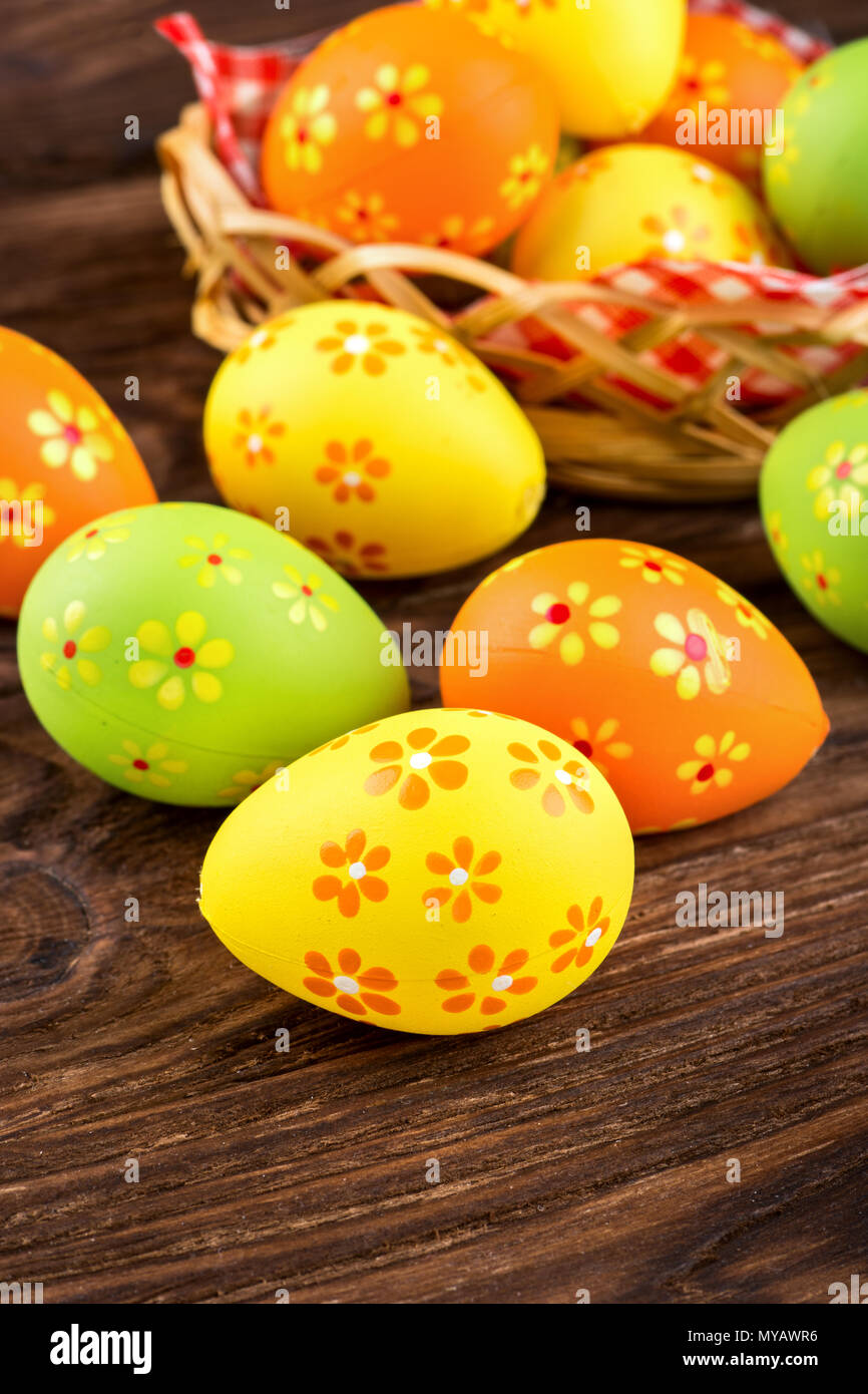 Scattered multi-colored Easter eggs with basket on the table Stock Photo
