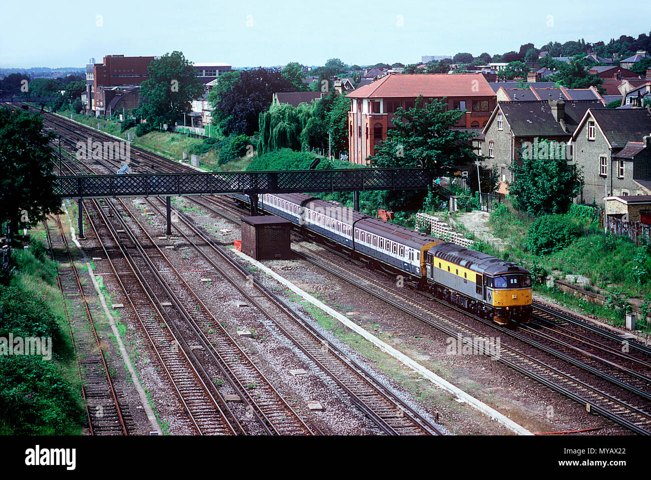 A class 33 diesel locomotive number 33019 heads towards Clapham Junction with departmental 4EPB unit number 930997 in tow at Wimbledon on the 10th July 1992. Stock Photo