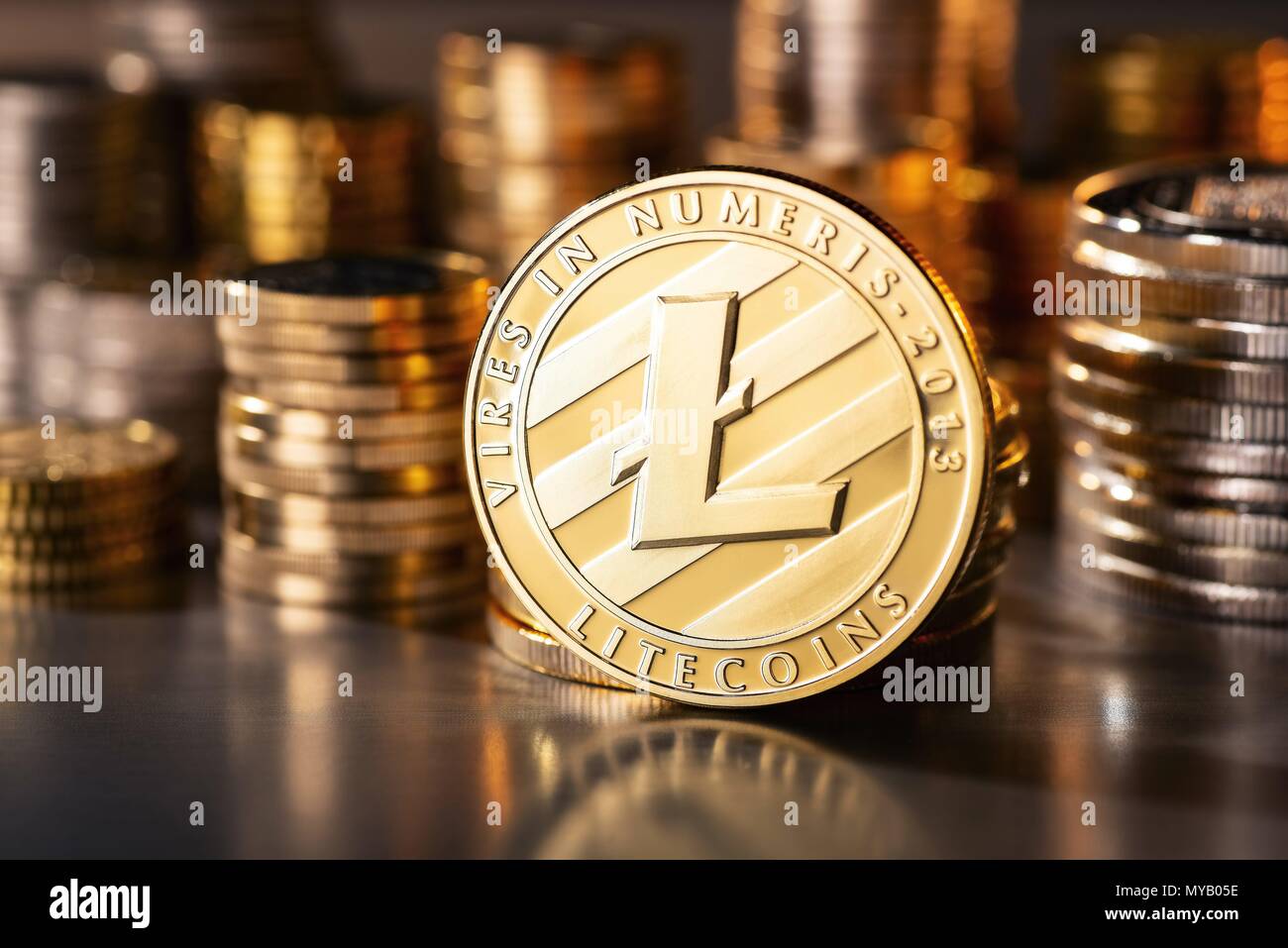 Coin of the crypto currency Litecoin with several stacks of coins in the background | usage worldwide Stock Photo