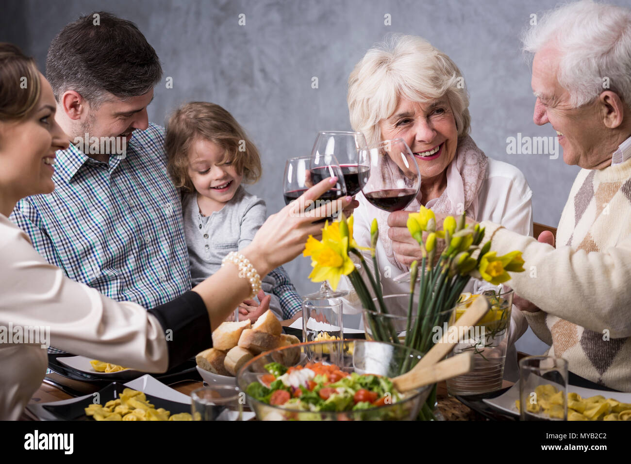 Happy family during holiday dinner, smiling, talking, drinking red wine Stock Photo