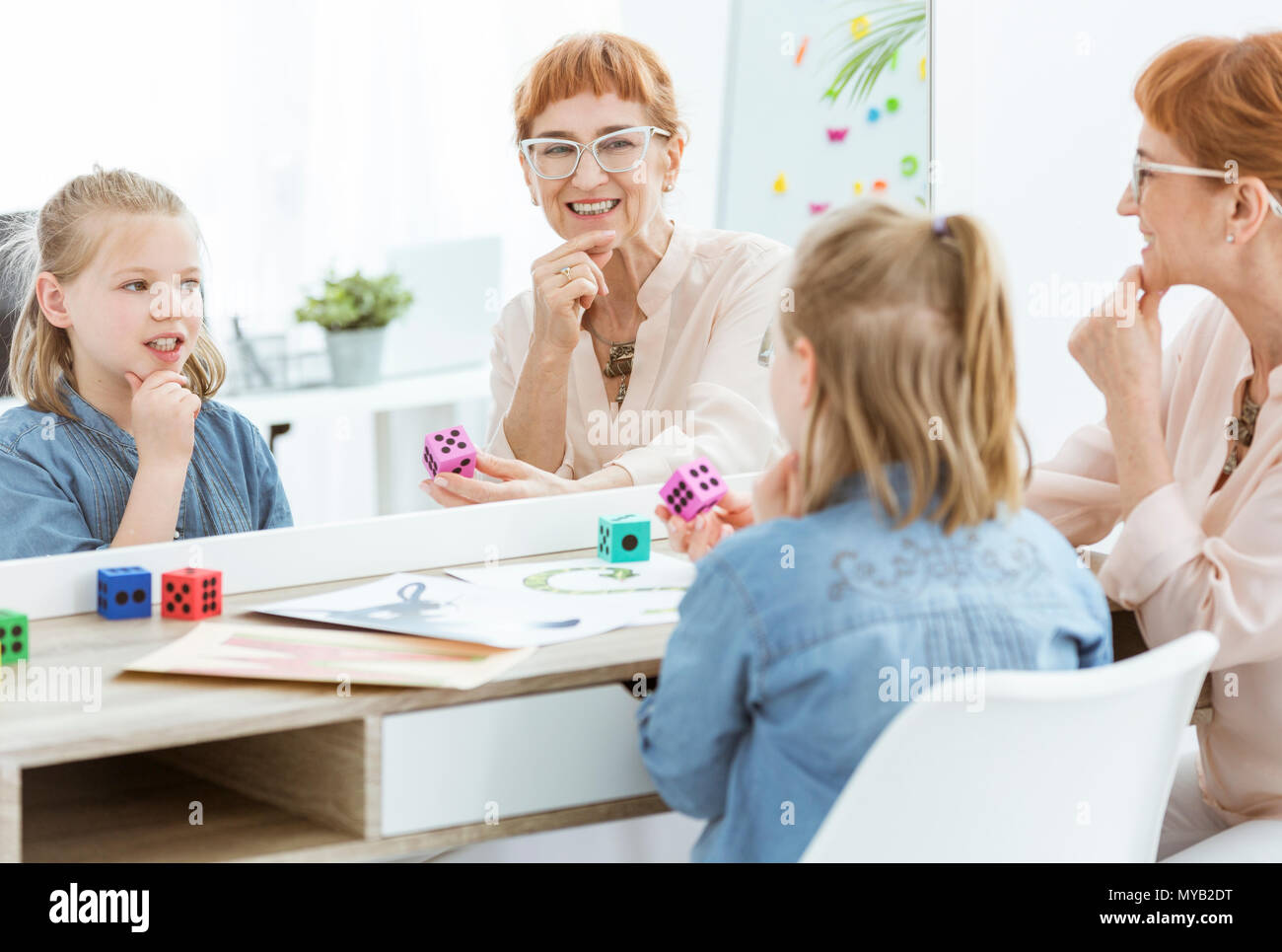 Speech therapist and little girl working in front of mirror Stock Photo