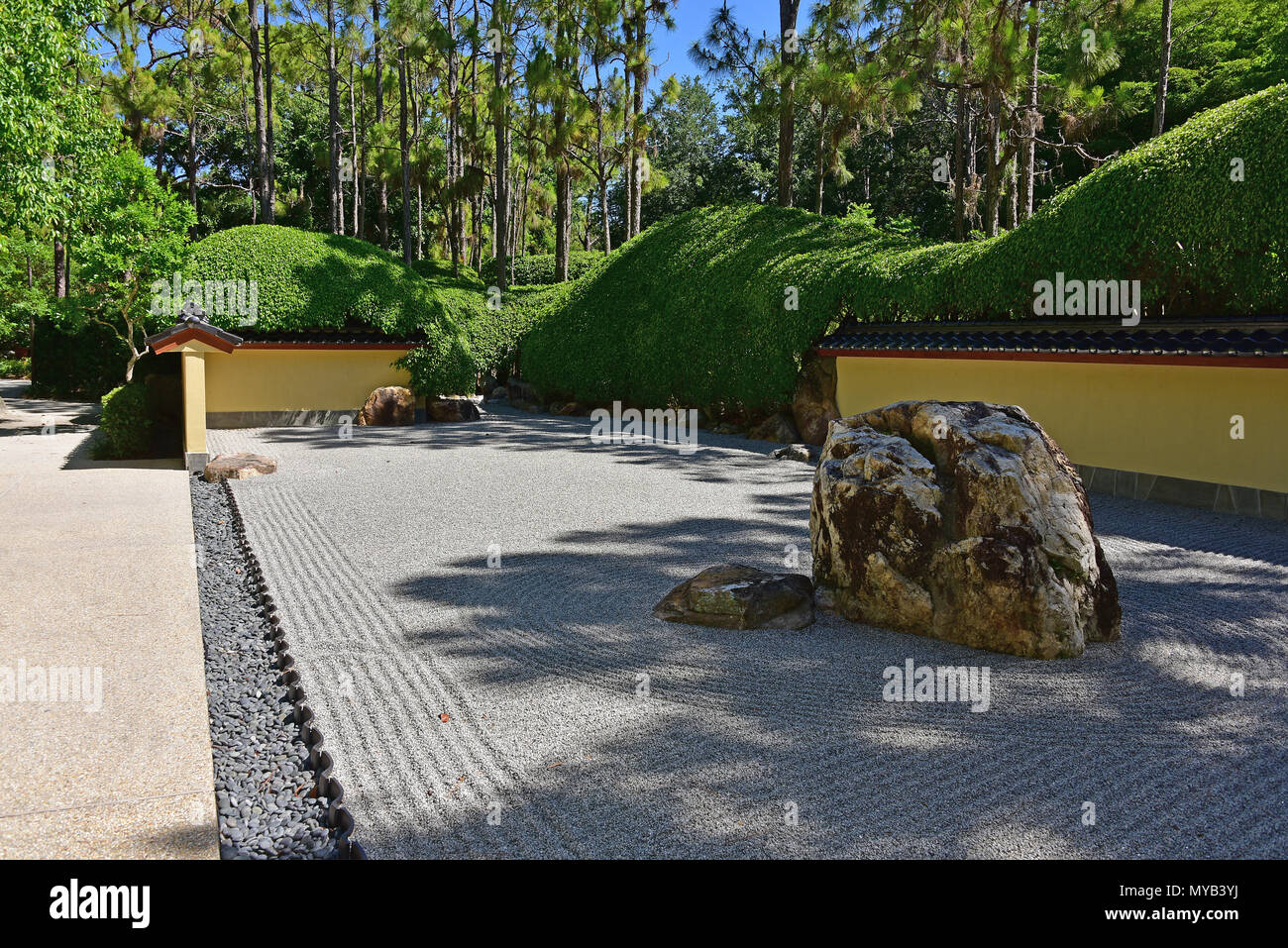 Rock garden at the Morikami Museum and Japanese Gardens, overall view with rocks, boundary wall and raked gravel, Delray Beach, FL, USA Stock Photo