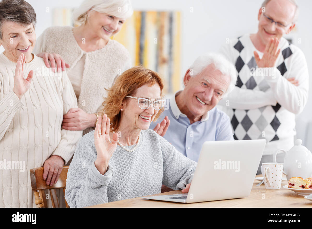 Elderly happy people talking online using laptop with old friend Stock Photo