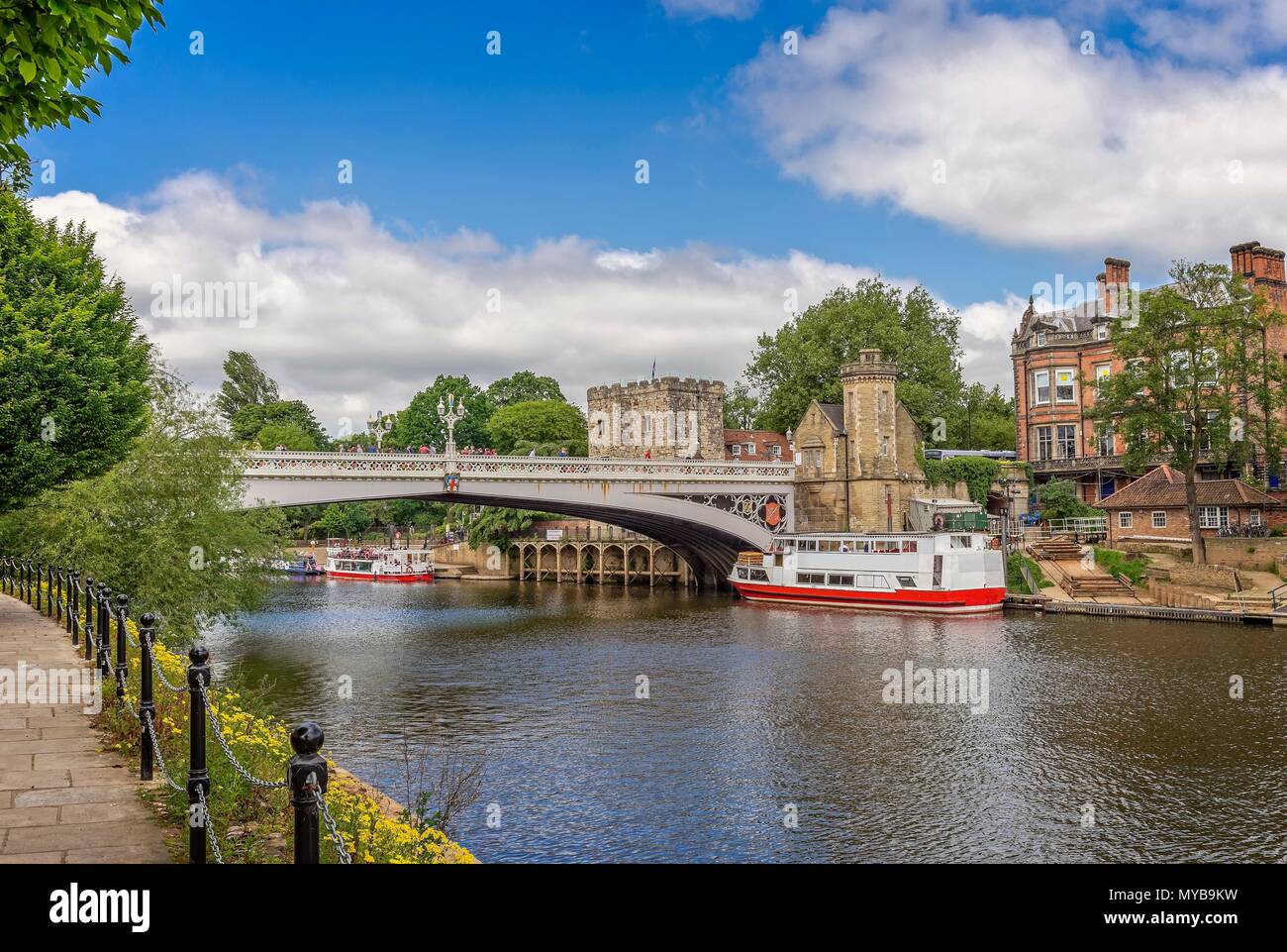 The 19th Century Lendal Bridge in York.  The River Ouse flows underneath with a river bank path in the foreground. Stock Photo