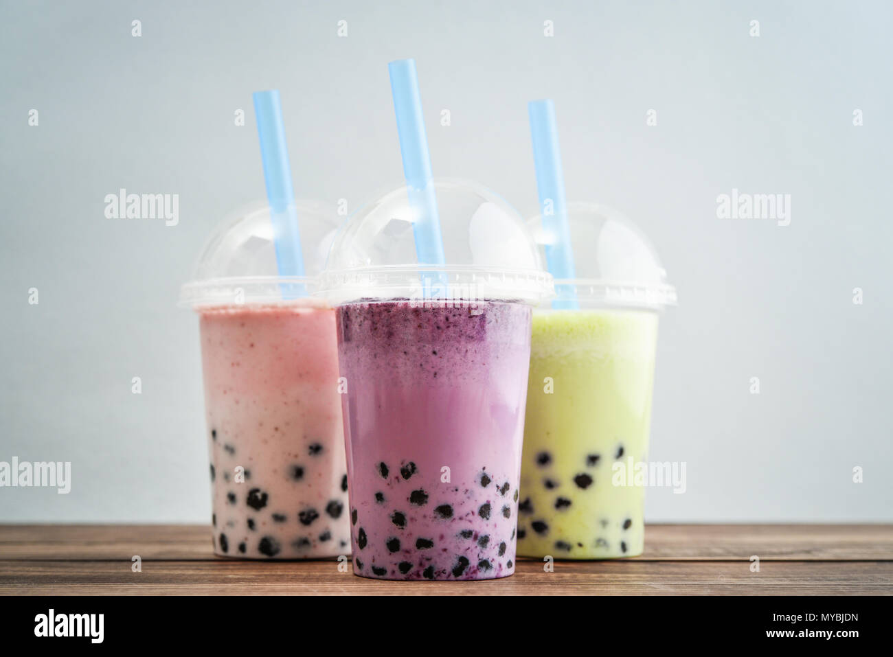 Various Bubble Tea in a plastic cups with drink straws on blue background.  Take away drinks concept Stock Photo - Alamy