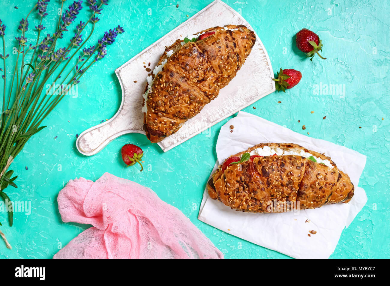 Cereal croissants with cream cheese and fresh strawberries. Useful breakfast. Proper nutrition