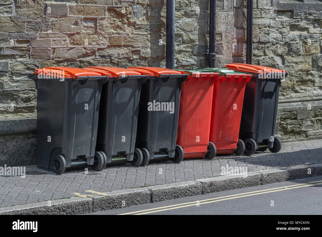 Row of industrial / commercial wheelie bins / rubbish bins outside shop premises in Truro, Cornwall. Redundant data metaphor, refuse collection. Stock Photo