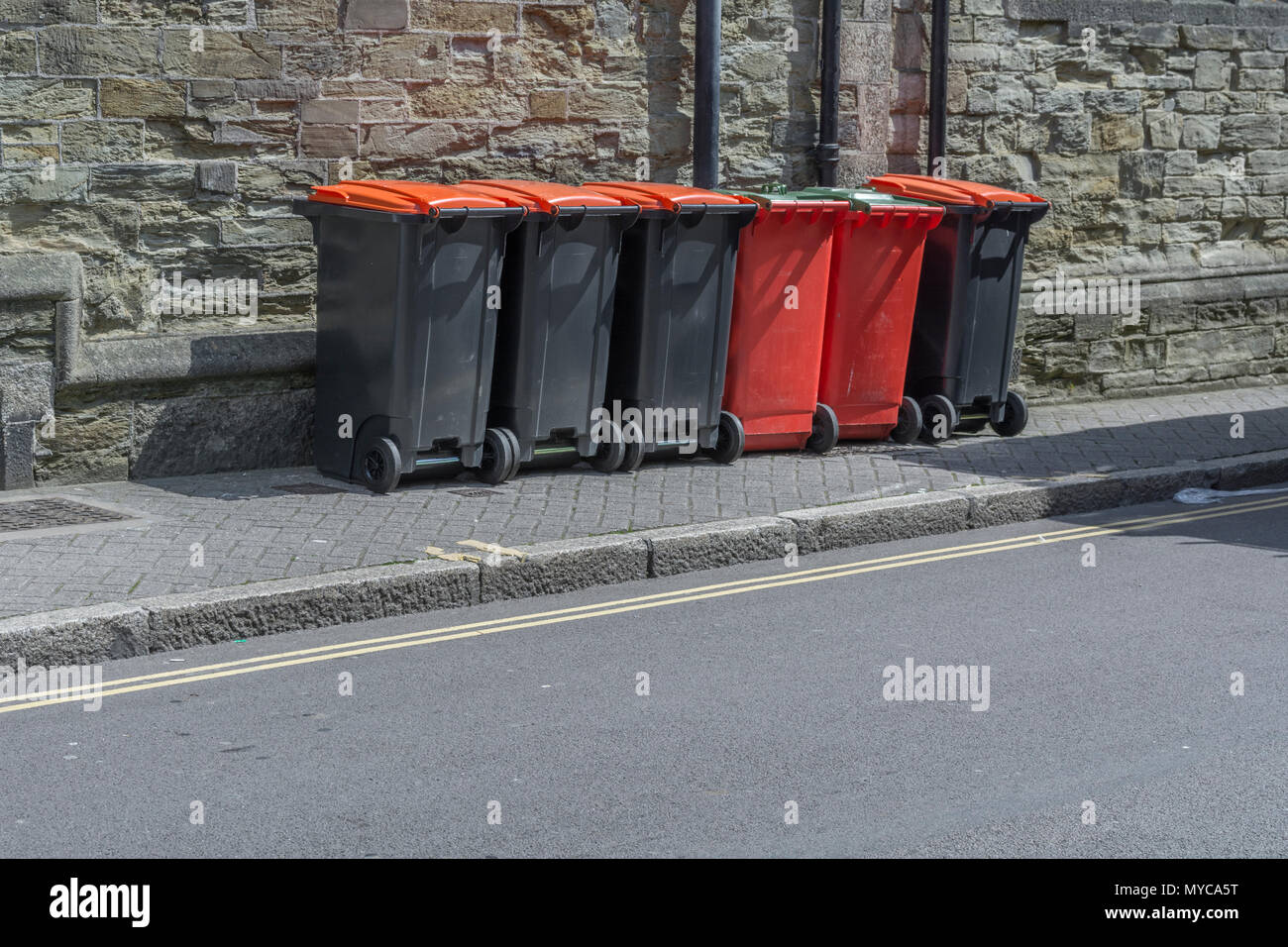 Row of industrial / commercial wheelie bins / rubbish bins outside shop premises in Truro, Cornwall. Redundant data metaphor, refuse collection. Stock Photo