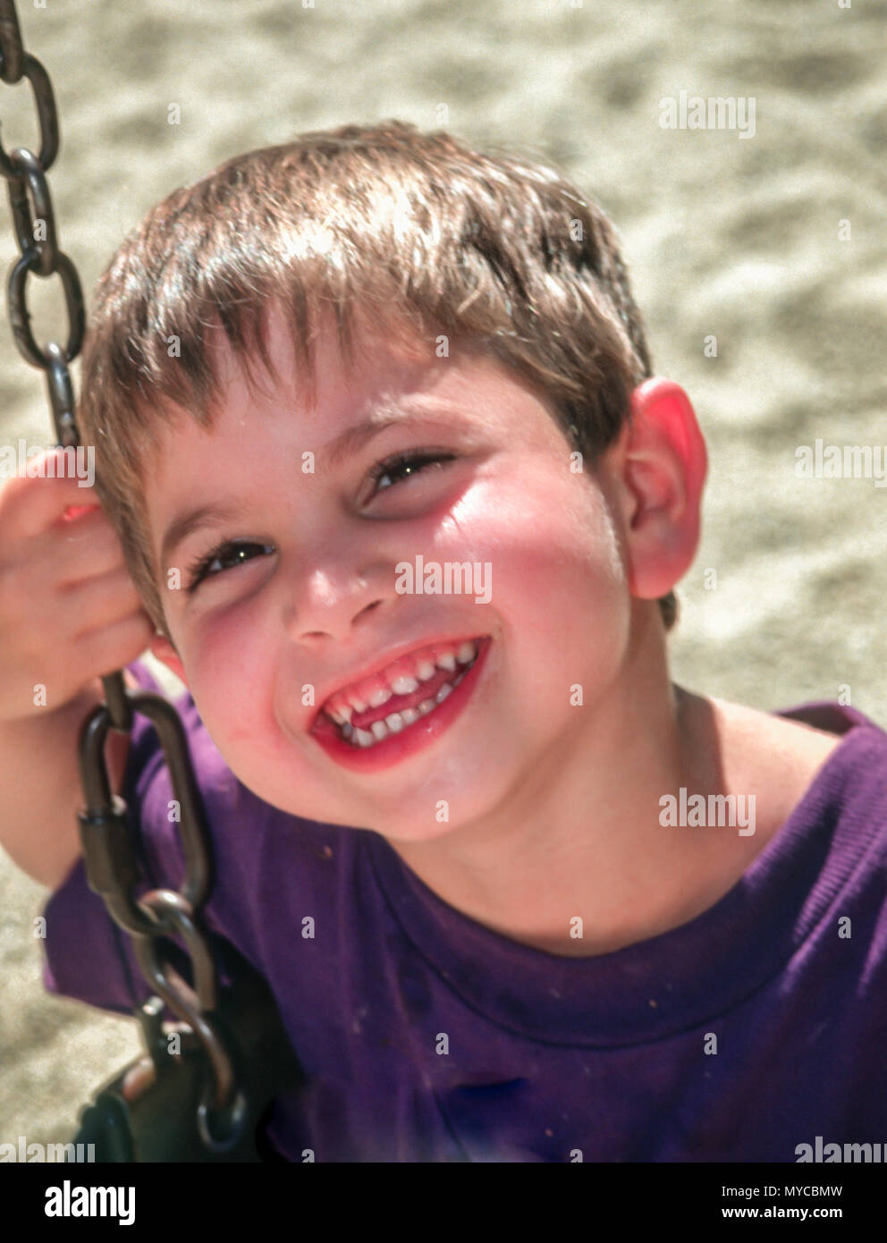 Happy Pre school age 3-5 years old child playing on swing in playground. MR  © Myrleen Pearson.  ........Ferguson Cate Stock Photo
