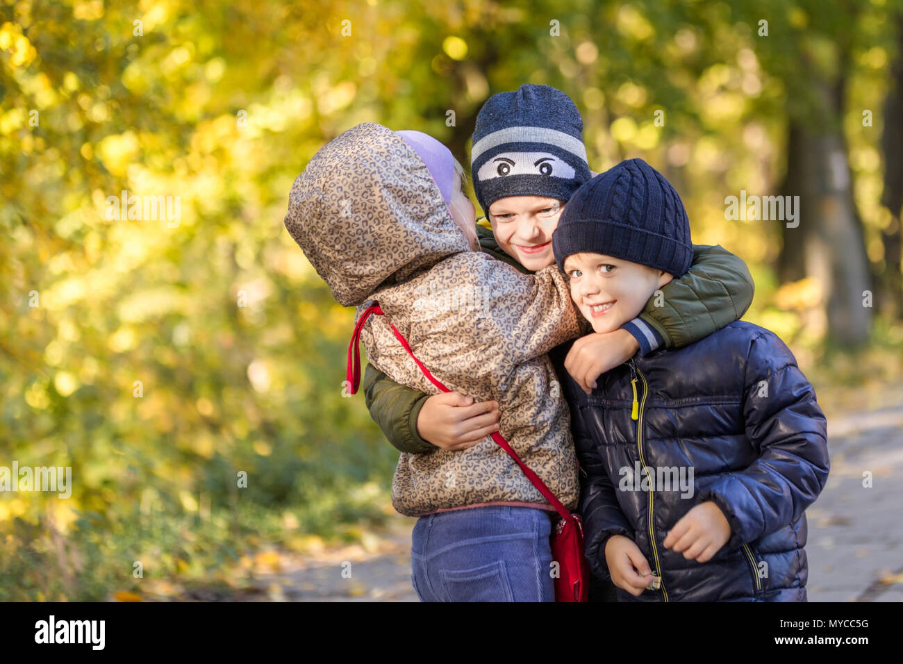 Group of happy three kids having fun outdoors in autumn park. Cute ...