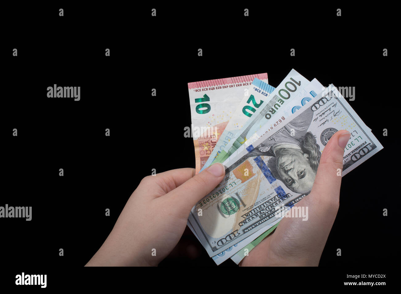 Hand holding American dollar banknotes isolated on black background ...
