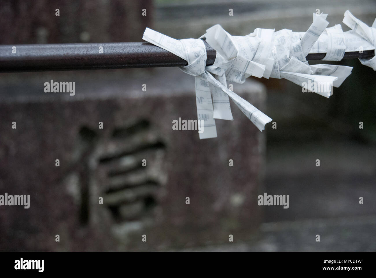 Japan wishing paper knot, a stone with chinese calligraphy, meaning belief Stock Photo