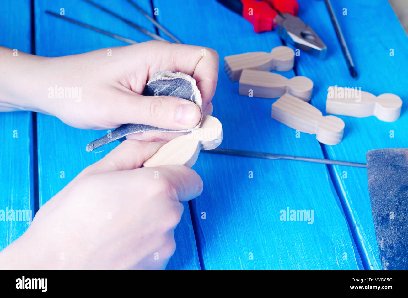 The master processes the wood with his hands. Working hands on a blue ...