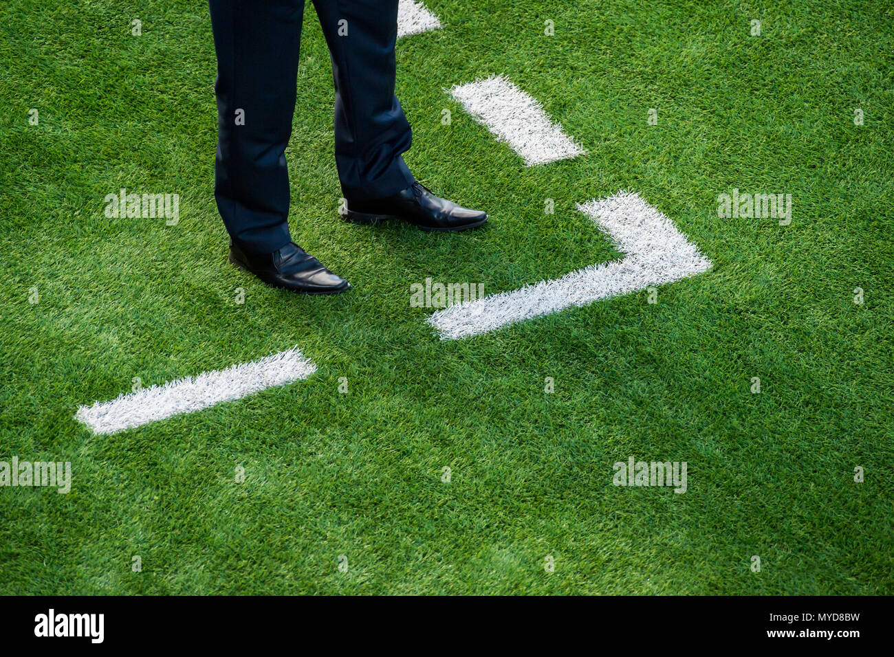 Coach standing next to chalk line on soccer field Stock Photo Alamy