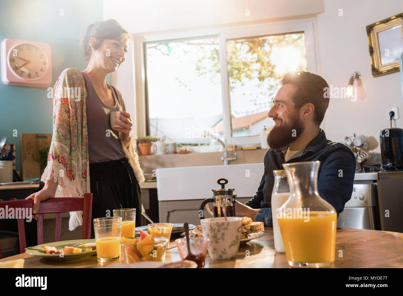 Cheerful couple having breakfast in the kitchen of their house Stock Photo