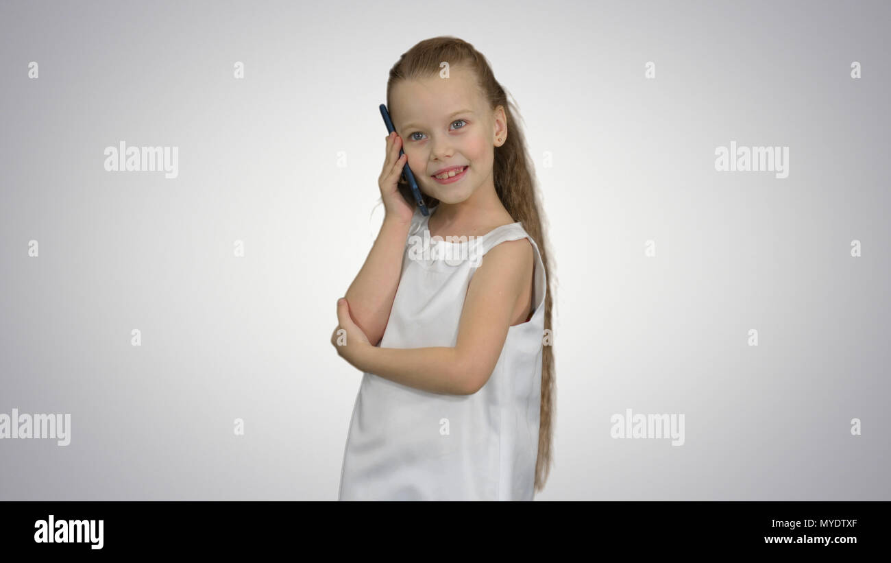 Cute little girl talking on the cell phone on white background Stock ...
