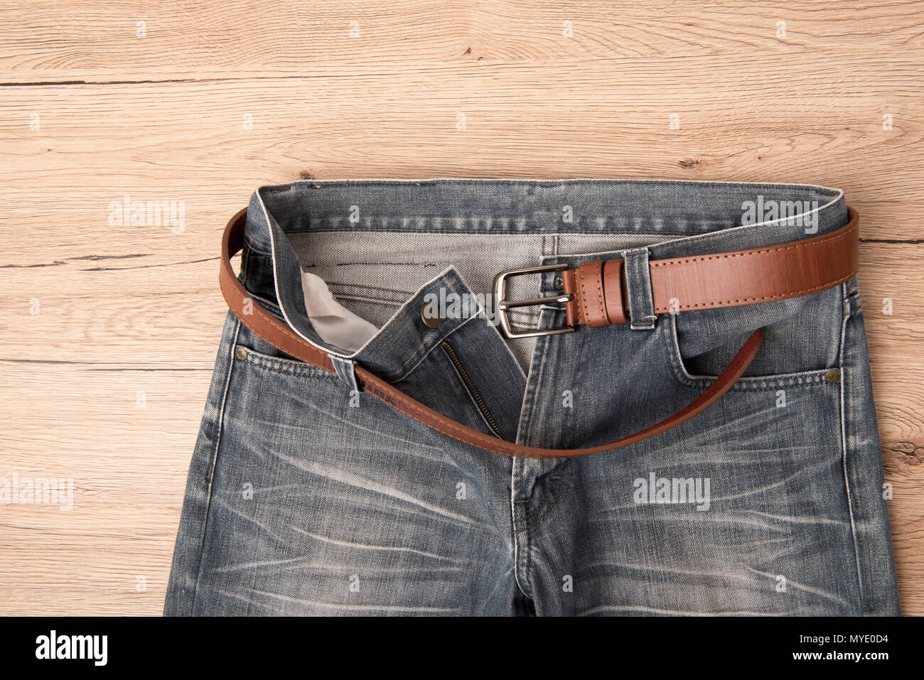 Top view Jeans and leather belt pace on wooden background Stock Photo -  Alamy