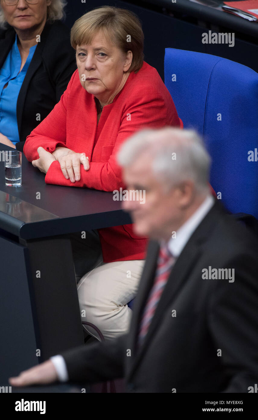 Berlin, Germany. 7th June, 2018. German chancellor Angela Merkel (Christian Democratic Union) watches as Horst Seehofer of the Christian Social Union (CSU), federal interior minister, speaks during a plenary meeting of the German parliament at the Reichstag building. Main themes of the 36th session of the 19th legislature period include new refugee family reunion laws, foreign deployments of the German army, rising rent prices in Germany as well as a committee of inquiry requested by the Free Democratic Party concerning the Federal Office for Migration and Refugees (BAMF) affair. Credit: dpa p Stock Photo