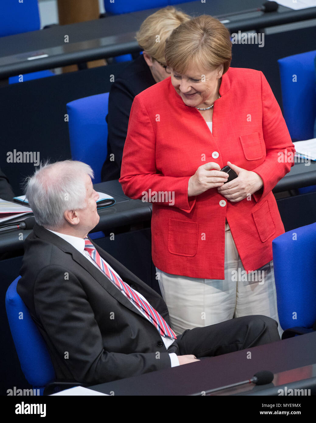 Berlin, Germany. 7th June, 2018. German chancellor Angela Merkel (Christian Democratic Union) speaks with Horst Seehofer of the Christian Social Union (CSU), federal interior minister, during a plenary meeting of the German parliament at the Reichstag building. Main themes of the 36th session of the 19th legislature period include new refugee family reunion laws, foreign deployments of the German army, rising rent prices in Germany as well as a committee of inquiry requested by the Free Democratic Party concerning the Federal Office for Migration and Refugees (BAMF) affair. Photo: Bernd von Ju Stock Photo