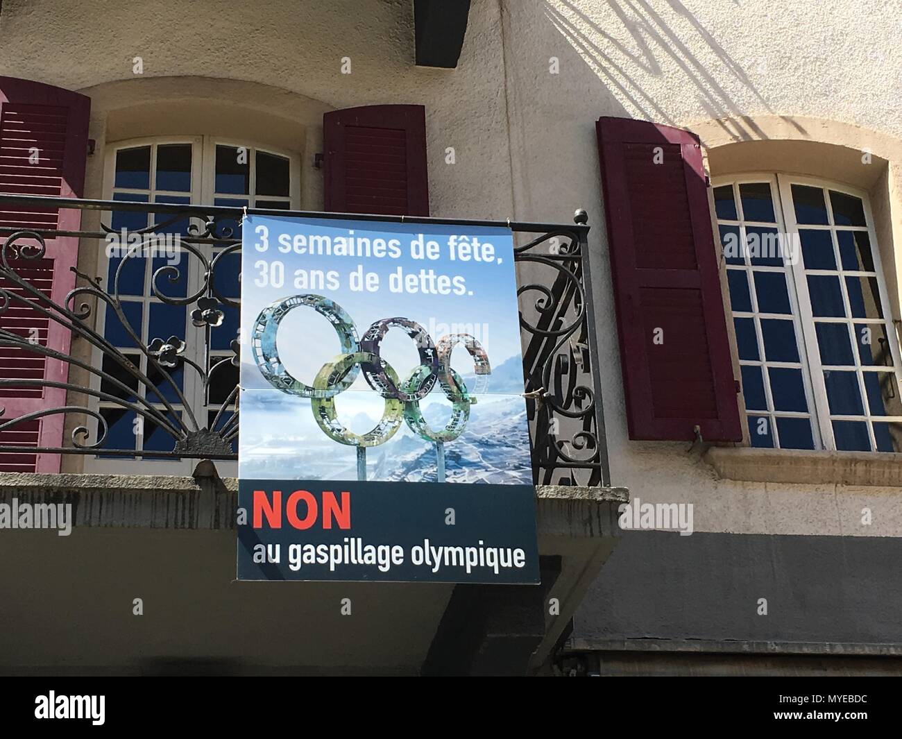 FILED - 14 May 2018, Switzerland, Sion: A poster of opponents of an  application for the 2026 Olympic Games hangs on a balcony. "3 weeks hard  and 30 years debt" is it.