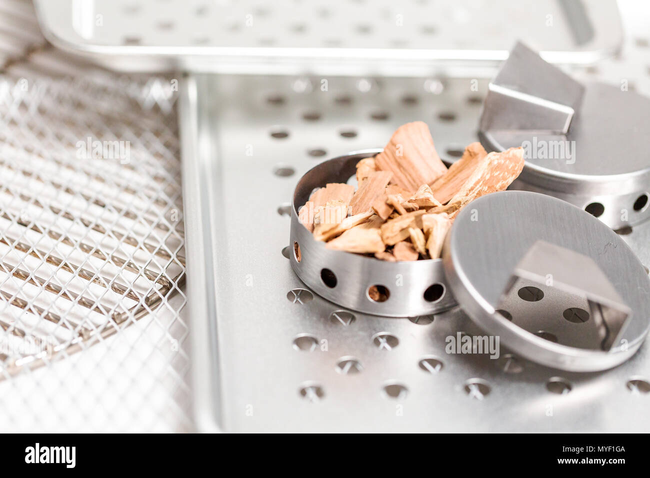 Stainless steel smoking pucks with smoking apple chips Stock Photo Alamy