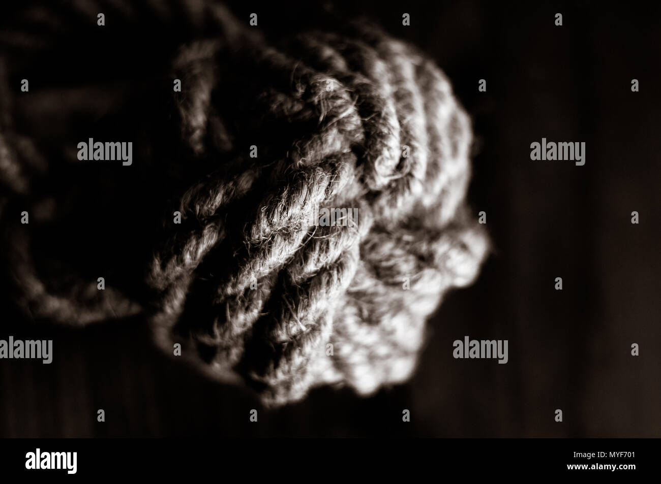 fender marine knot of thick brown rope on a wooden background