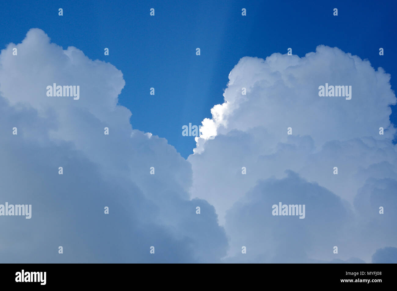 Sun Rays through Billowy Clouds Stock Photo - Alamy