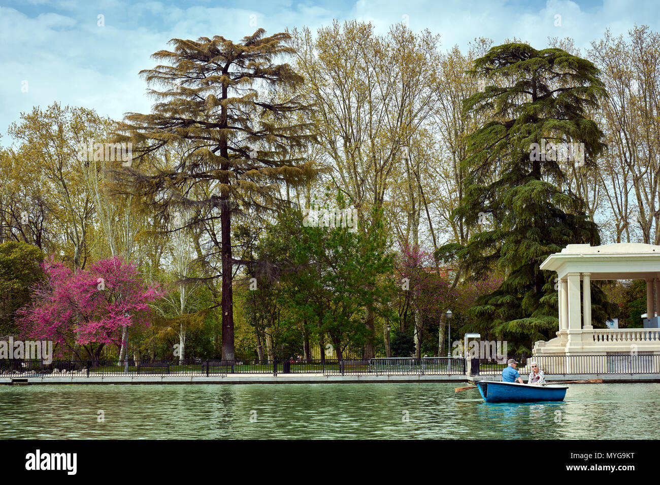 MADRID, SPAIN - APRIL 23, 2018: Beautiful view with trees and people enjoying a raft ride in the Big Pond in the Park of Good Retirement. Stock Photo