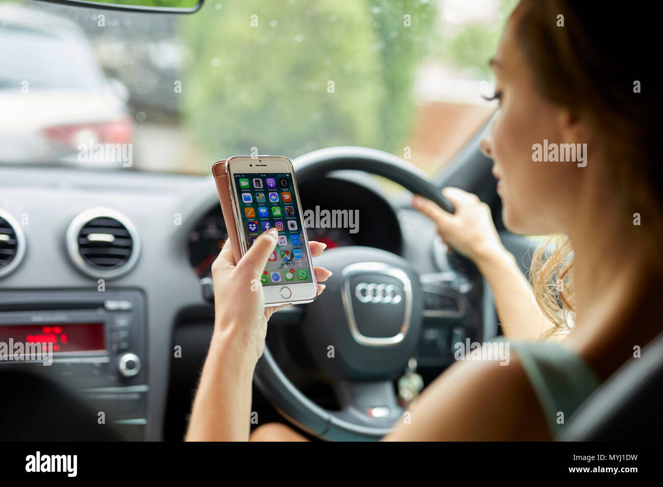 Woman driving whilst using mobile phone Stock Photo