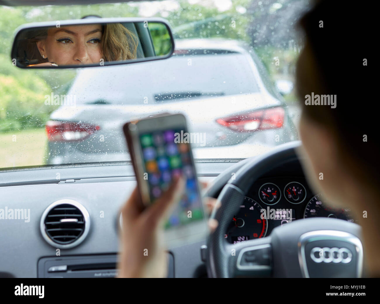 Woman driving whilst using mobile phone Stock Photo