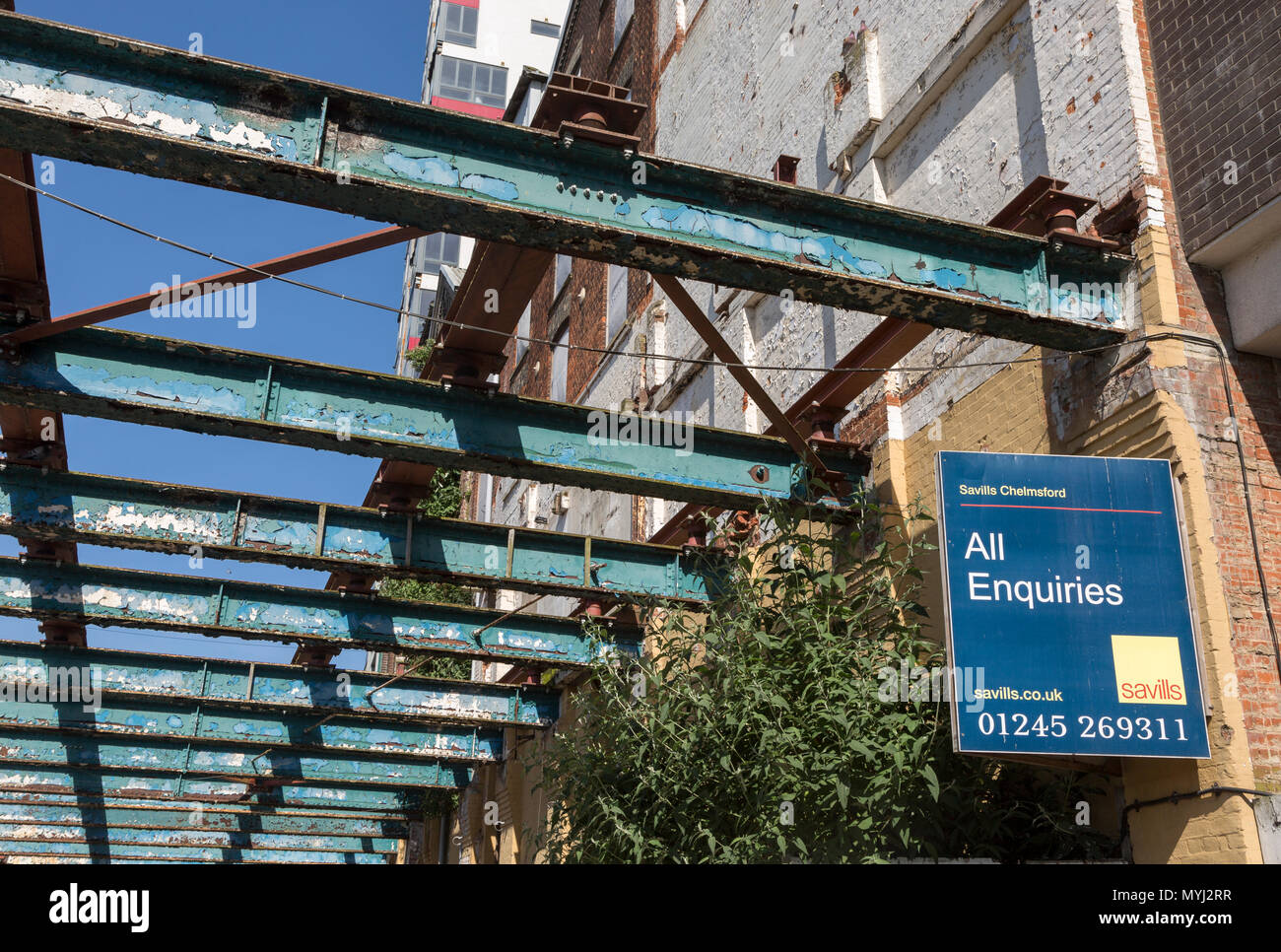 Savills estate agent sign All Enquiries on derelict factory building