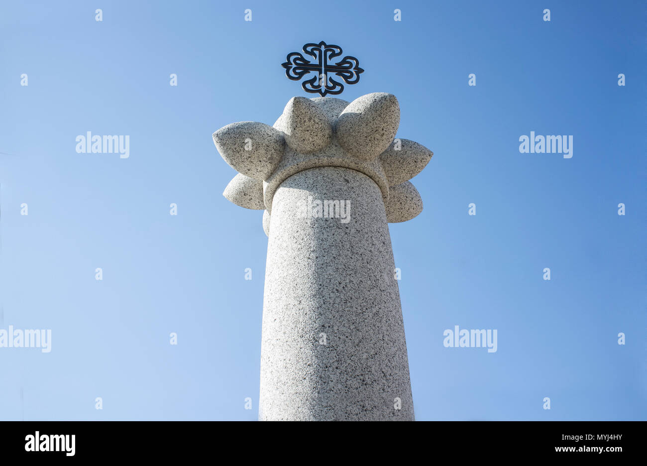 Granite monolith or pillory with Calatrava Orden Cross on the top. Saceruela, Spain Stock Photo